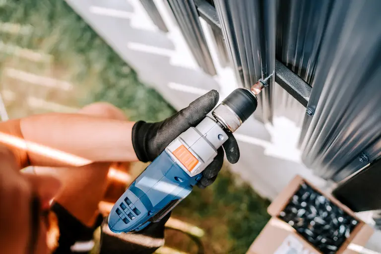 installation de portes garage asap Personne utilisant une perceuse électrique.