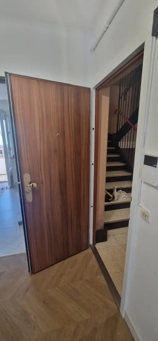Porte ouverte sur un couloir et des escaliers.