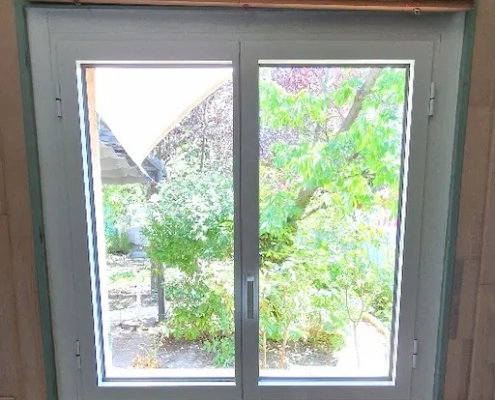 Vue jardin depuis fenêtre intérieure.