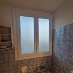 Fenêtre de salle de bain avec carrelage bleu.