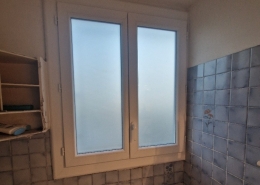 Fenêtre de salle de bain avec carrelage bleu.