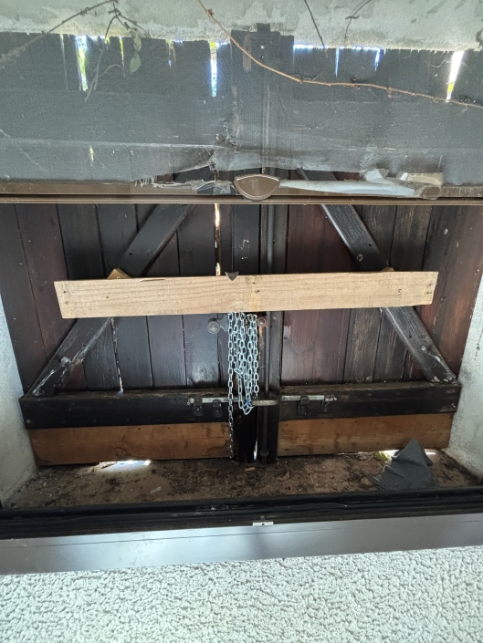Porte en bois renforcée par une barre et chaîne.