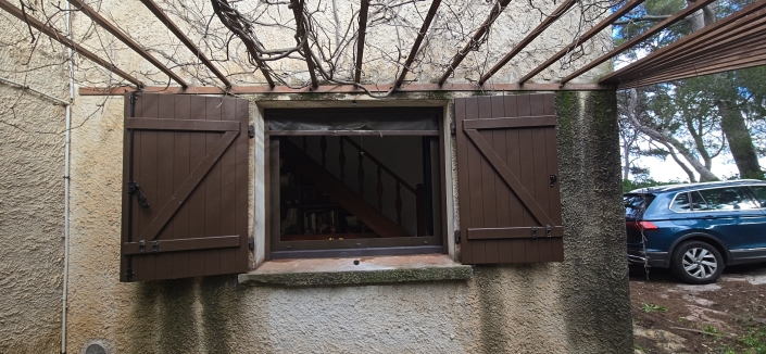 Fenêtre ouverte avec volets en bois.