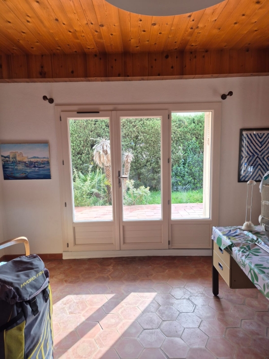 Intérieur lumineux avec porte-fenêtre donnant sur jardin.
